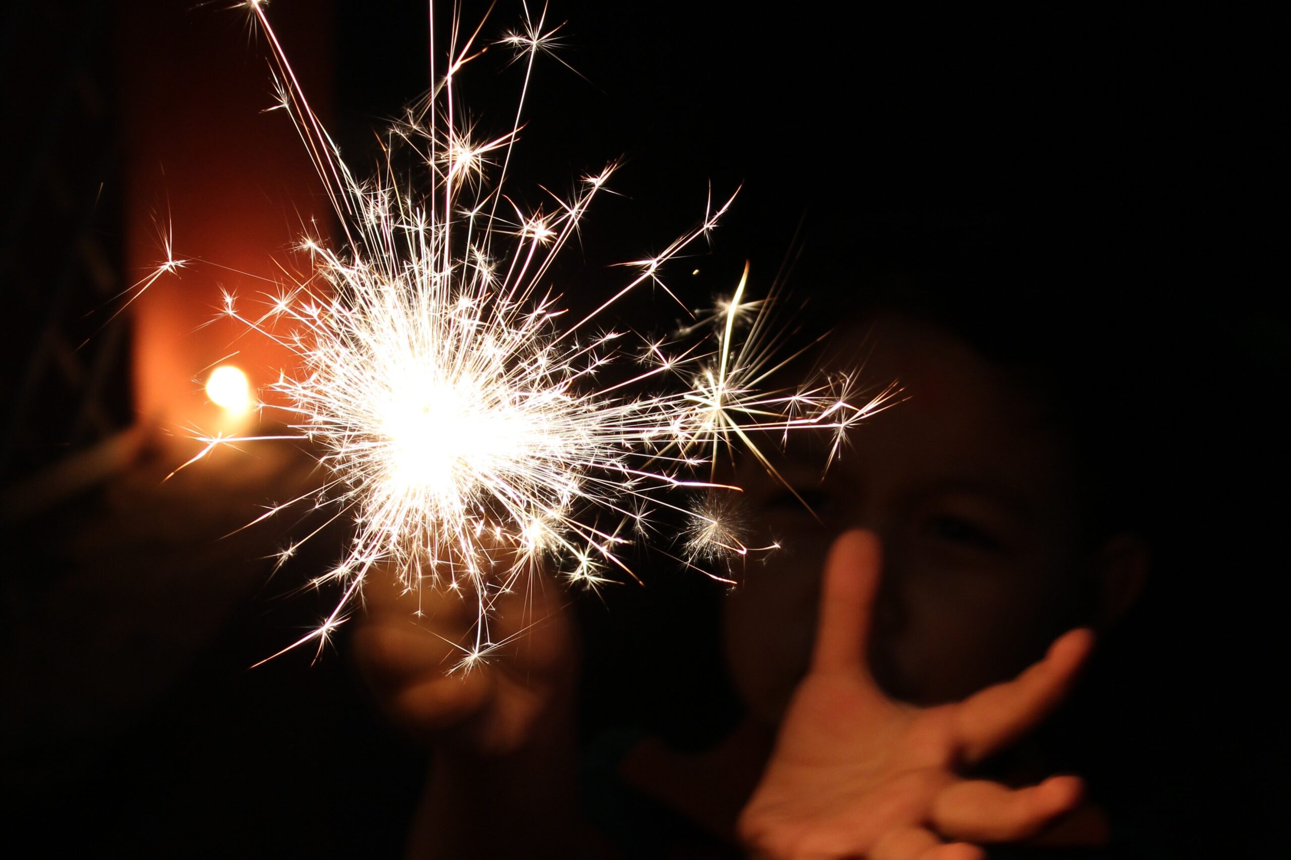 outspread hand underneath a lit sparkler